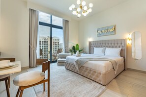 Ein modernes Hotelzimmer mit einem großen Bett, einem Essbereich und Blick auf die Stadt.