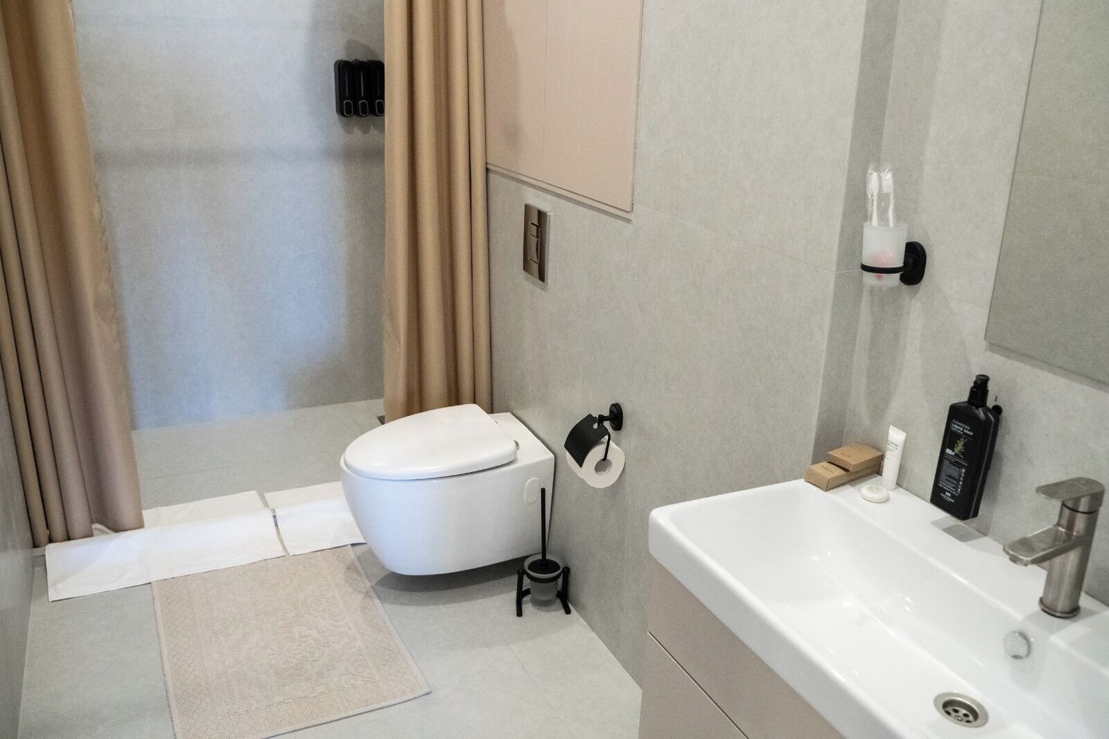 Een moderne badkamer met toilet, wastafel en douche.