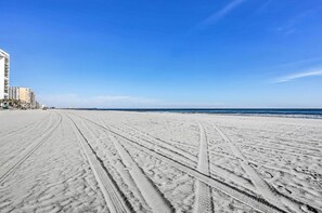 A beach with visible tire tracks and a clear blue sky. - Oceanfront Myrtle Beach Getaway w/ Balcony (Myrtle Beach)