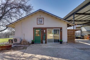 A building with a green door, a sign above the door, and a covered area to the right.