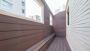 A narrow corridor with wooden paneling and a window. - Hotel Stay Yeoyu (Seoul)