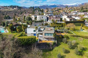 Zona residencial con casas modernas, piscina y montañas al fondo.