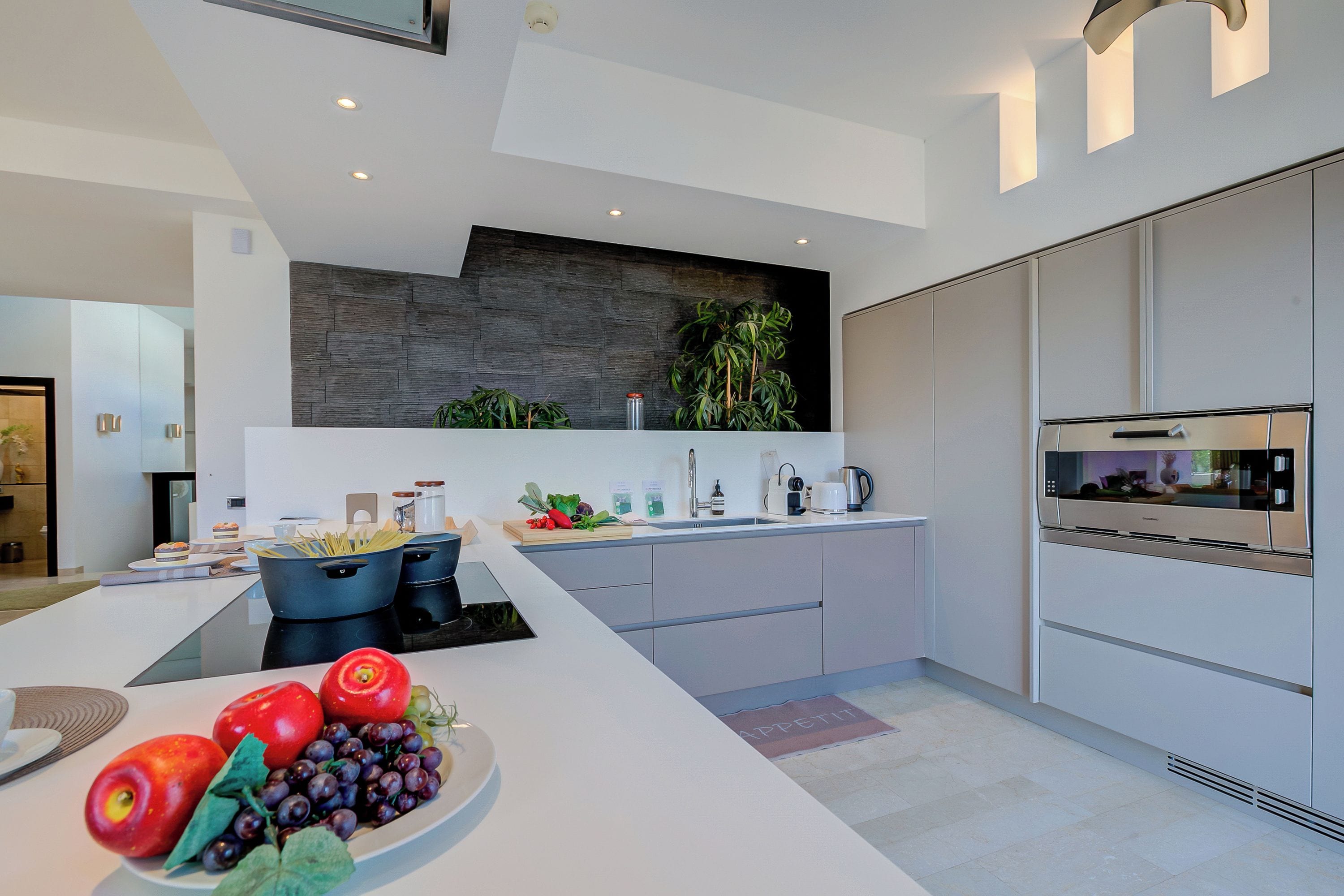 A modern kitchen with a central island, built-in appliances, and a minimalist design.