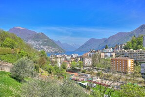 Un pueblo montañoso con edificios, un cielo azul despejado y vistas al mar.