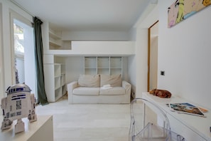A modern living room with a white sofa, a small table, and a clear glass partition. - Lugano Lake View Villa w. Private Pool (Lugano)