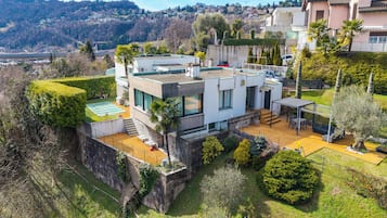 A modern house with a flat roof, large windows, and a well-maintained garden.