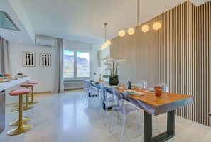 Un comedor moderno con una mesa de madera, sillas transparentes y una lámpara decorativa.