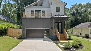 Ein zweistöckiges Haus mit Garage, Balkon und einer Treppe, die zum oberen Stock führt.