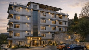 A multi-story hotel with a modern design, featuring balconies, large windows, and a stone facade. - Vista Luxurious Resort & Fun Park (Bhedetar)