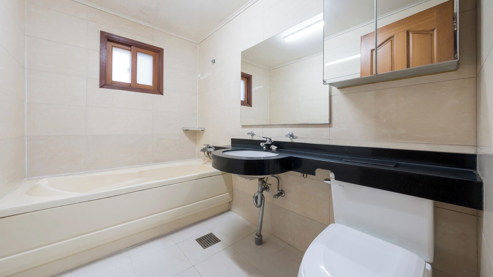 A bathroom with a bathtub, sink, toilet, and a mirror.