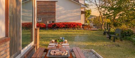 A patio with a grill, picnic table, and outdoor seating.