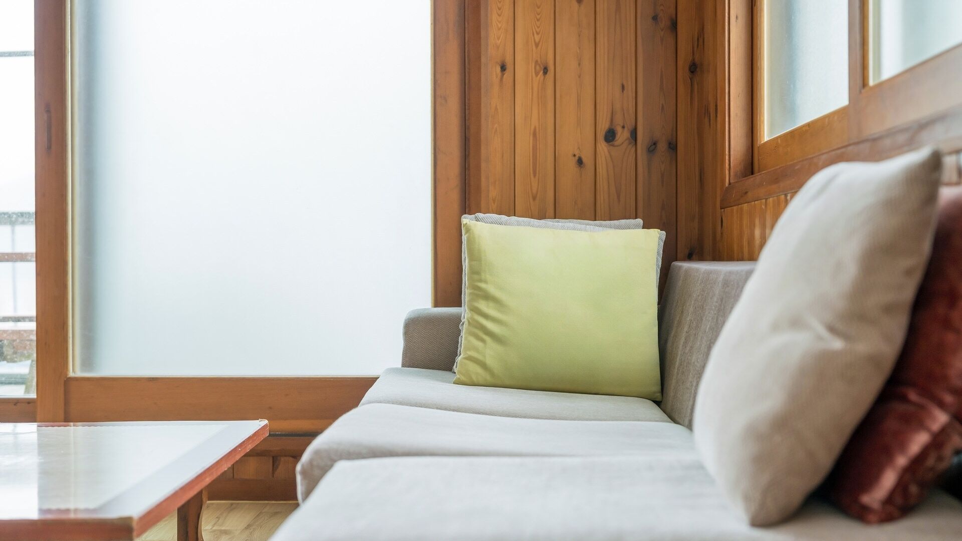Una sala moderna con un sofá, almohadas y una mesita.