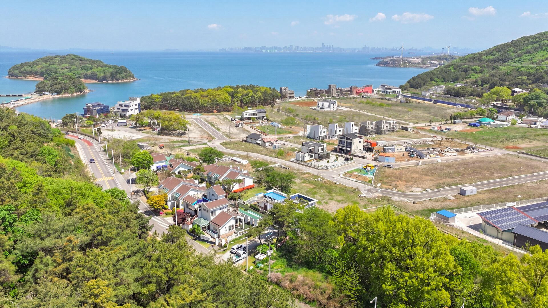A coastal town with residential houses, a marina, and industrial buildings.