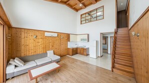 A room with a wooden ceiling, a sofa, a small table, a kitchenette, and a staircase. - Daebu-do, White Island Pension (Ansan)