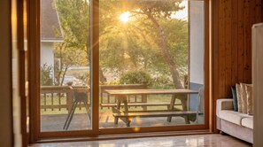 A room with a sliding glass door leading to an outdoor patio with a wooden table and benches. - Daebu-do, White Island Pension (Ansan)