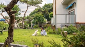 Un quartier résidentiel avec une pelouse, un chien et une personne.