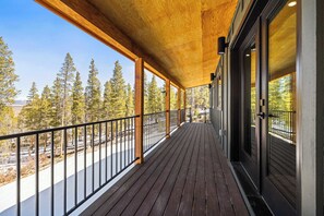 A wooden deck with a railing, large windows, and a view of trees. - 2BR New Home in Twin Lakes, Views, Pet Friendly (Twin Lakes)