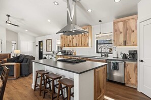 A modern kitchen with a central island, wooden cabinets, stainless steel appliances, and a ceiling fan. - 2BR New Home in Twin Lakes, Views, Pet Friendly (Twin Lakes)