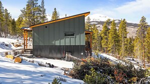 Una baita con tetto spiovente, una piccola finestra e un patio in legno.