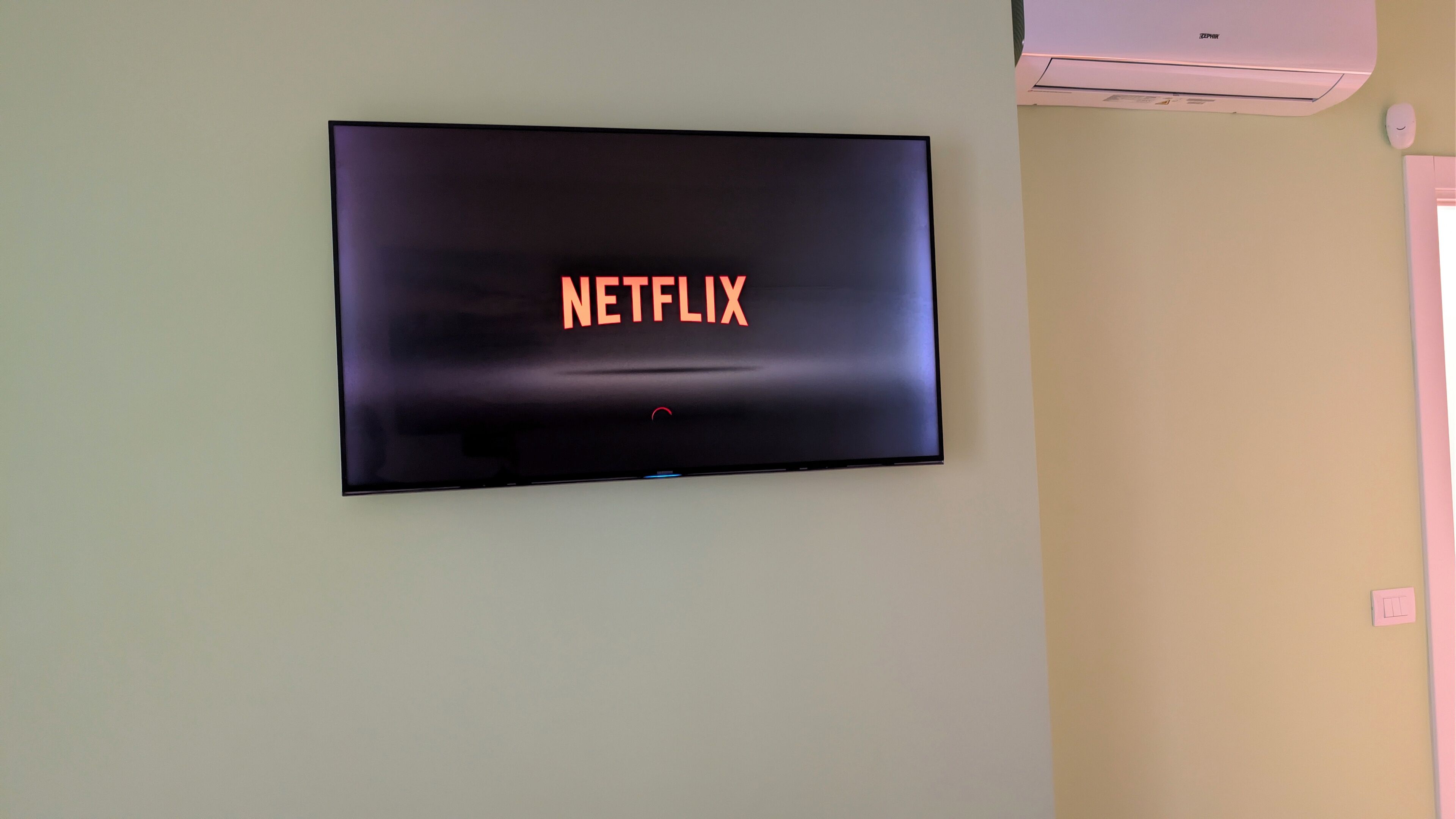 Un televisor montado en la pared mostrando el logotipo de Netflix.