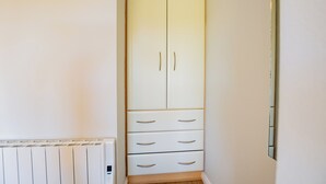 Un armario blanco con dos puertas y cuatro cajones.