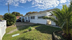 A residential house with a paved driveway, a garage, and a well-maintained lawn. - Quiet, friendly house for up to 6 people (Peyrehorade)