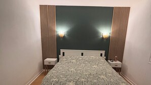 A bedroom with a large bed, two bedside tables, a headboard, and two wall-mounted lamps. - Quiet, friendly house for up to 6 people (Peyrehorade)