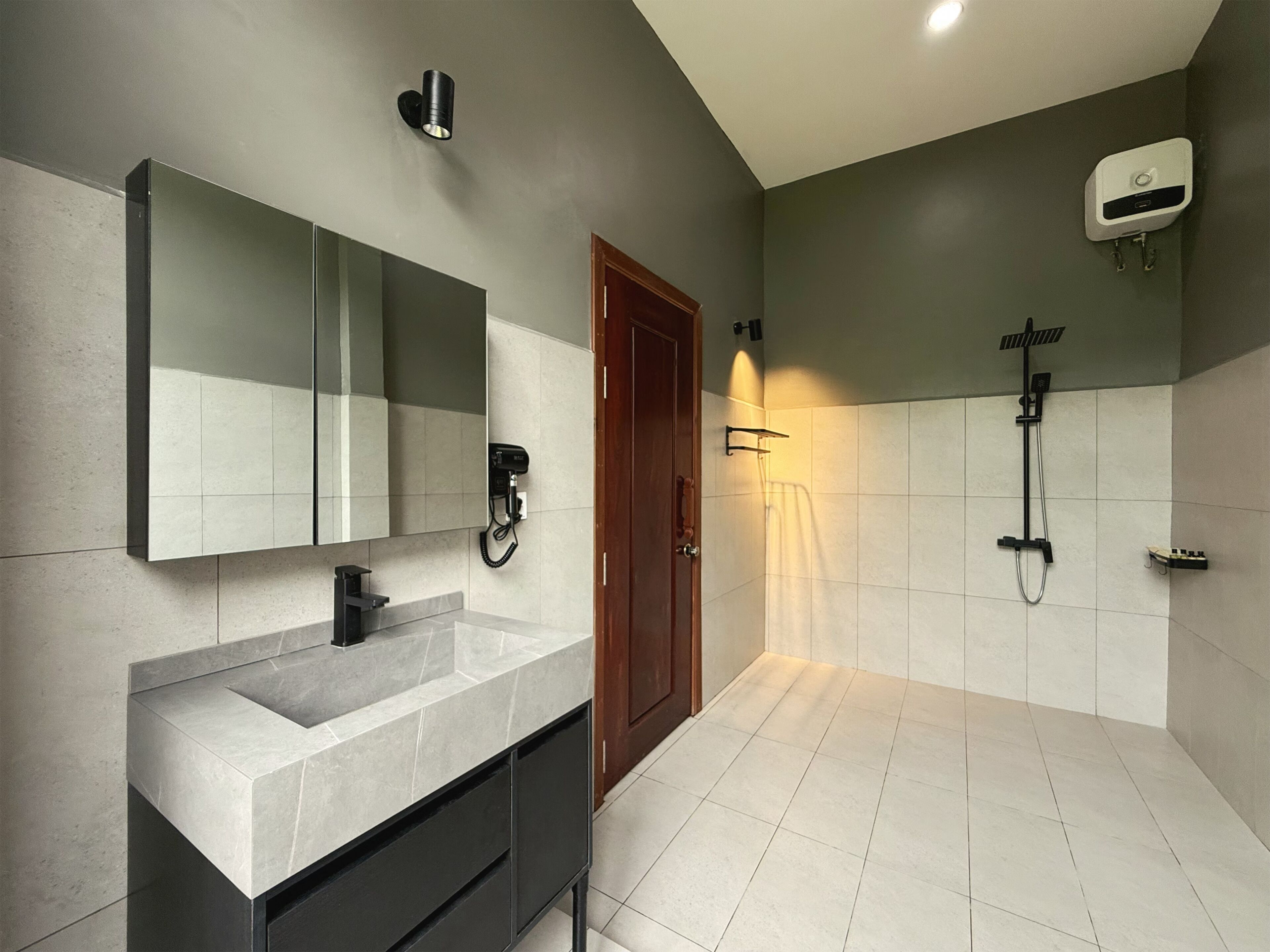A modern bathroom with a large mirror, a built-in sink, a shower, and a towel rack.