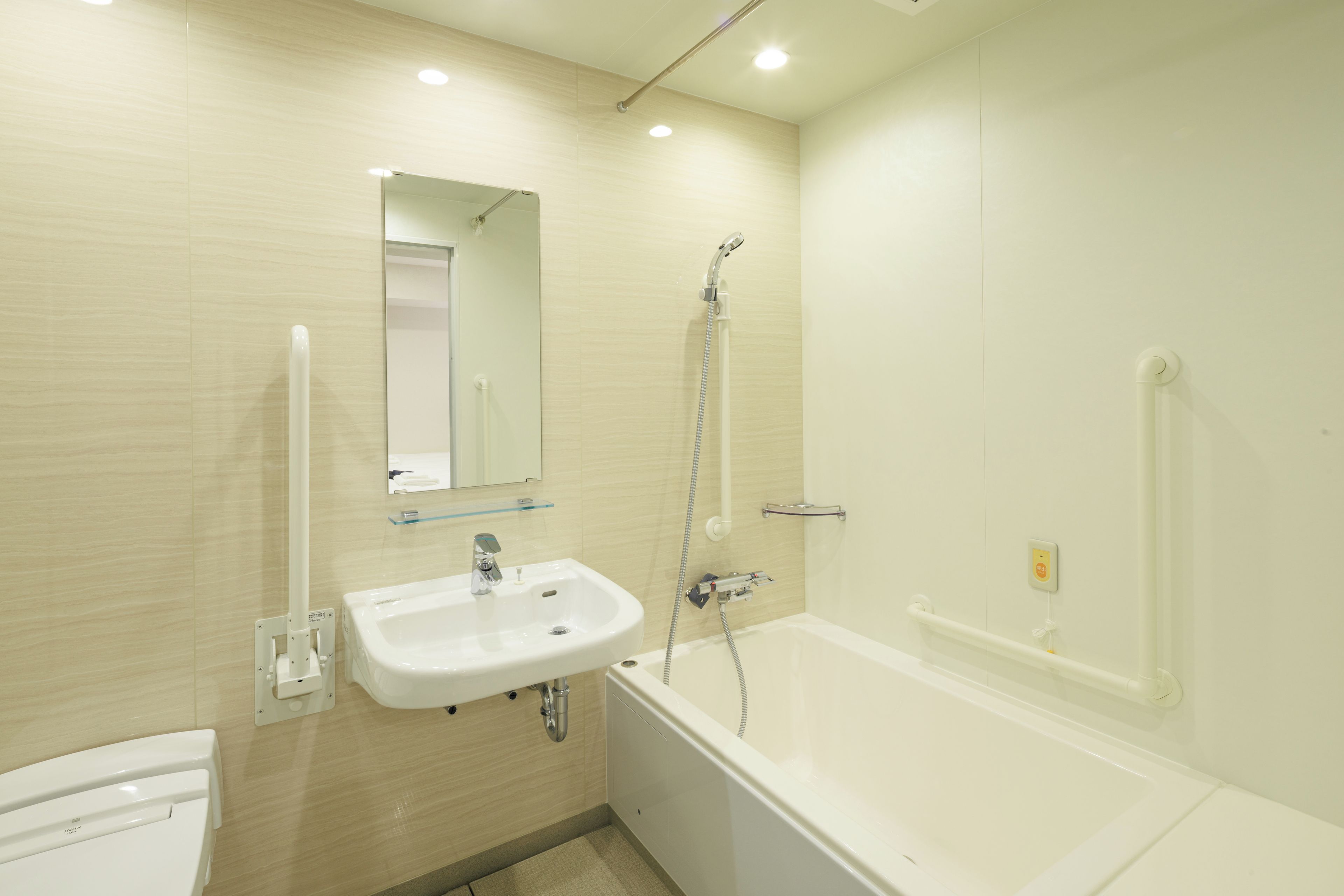 Un baño con lavamanos blanco, espejo y bañera.