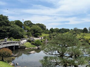 A traditional Japanese garden with a stone bridge, a pond, and lush greenery. - HOTEL AMANEK Kumamoto (Kumamoto)