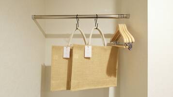 Two woven bags hanging on a metal rod, with tags attached.