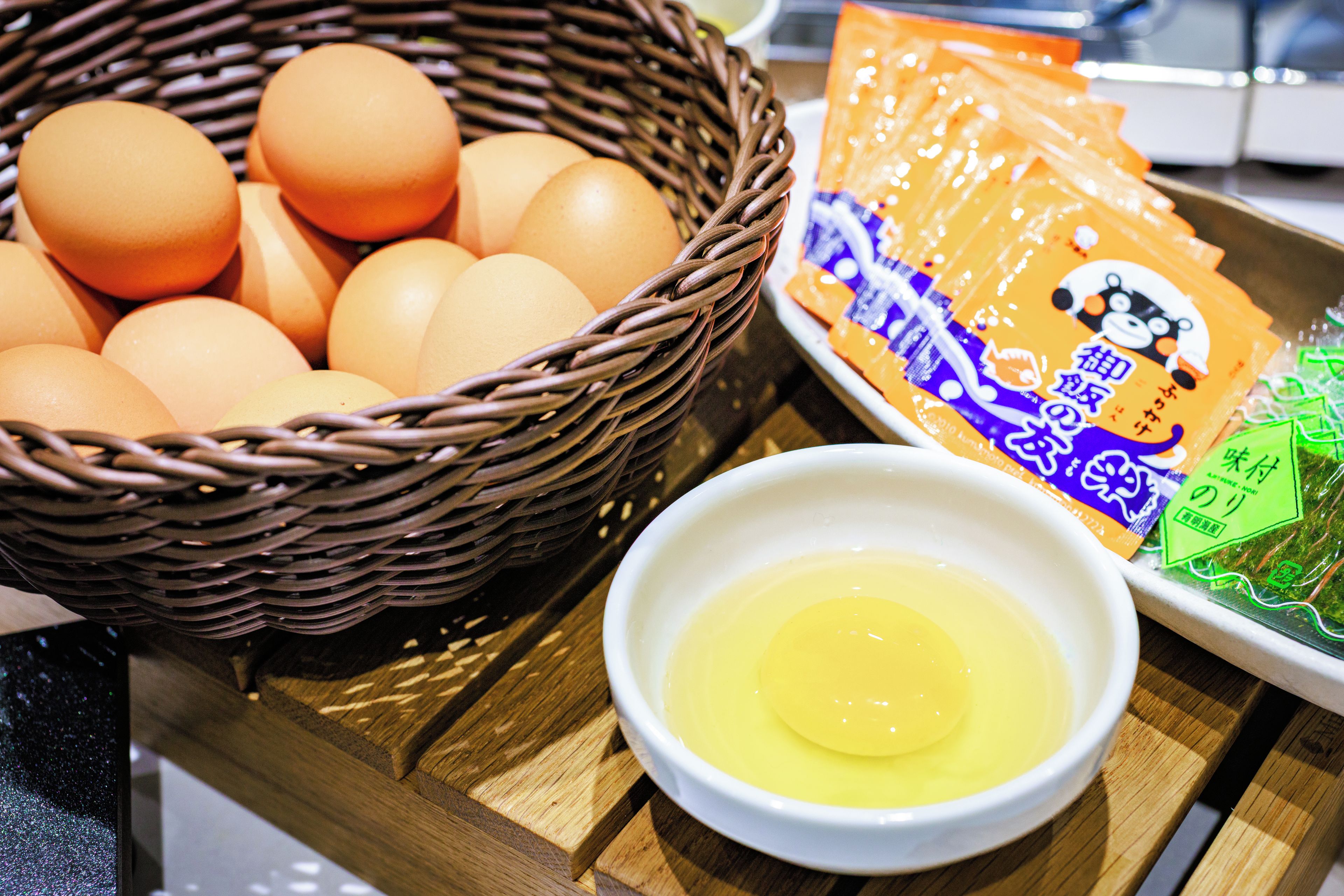A basket of eggs, a bowl of egg yolk, and a packet of seaweed.