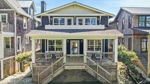 A two-story house with a front porch, a garage, and a small garden area.