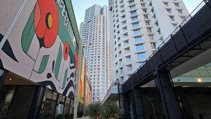 Een modern gebouw met een bijzondere gevel, gekenmerkt door geometrische patronen en een boom in een cirkelvormig ontwerp.