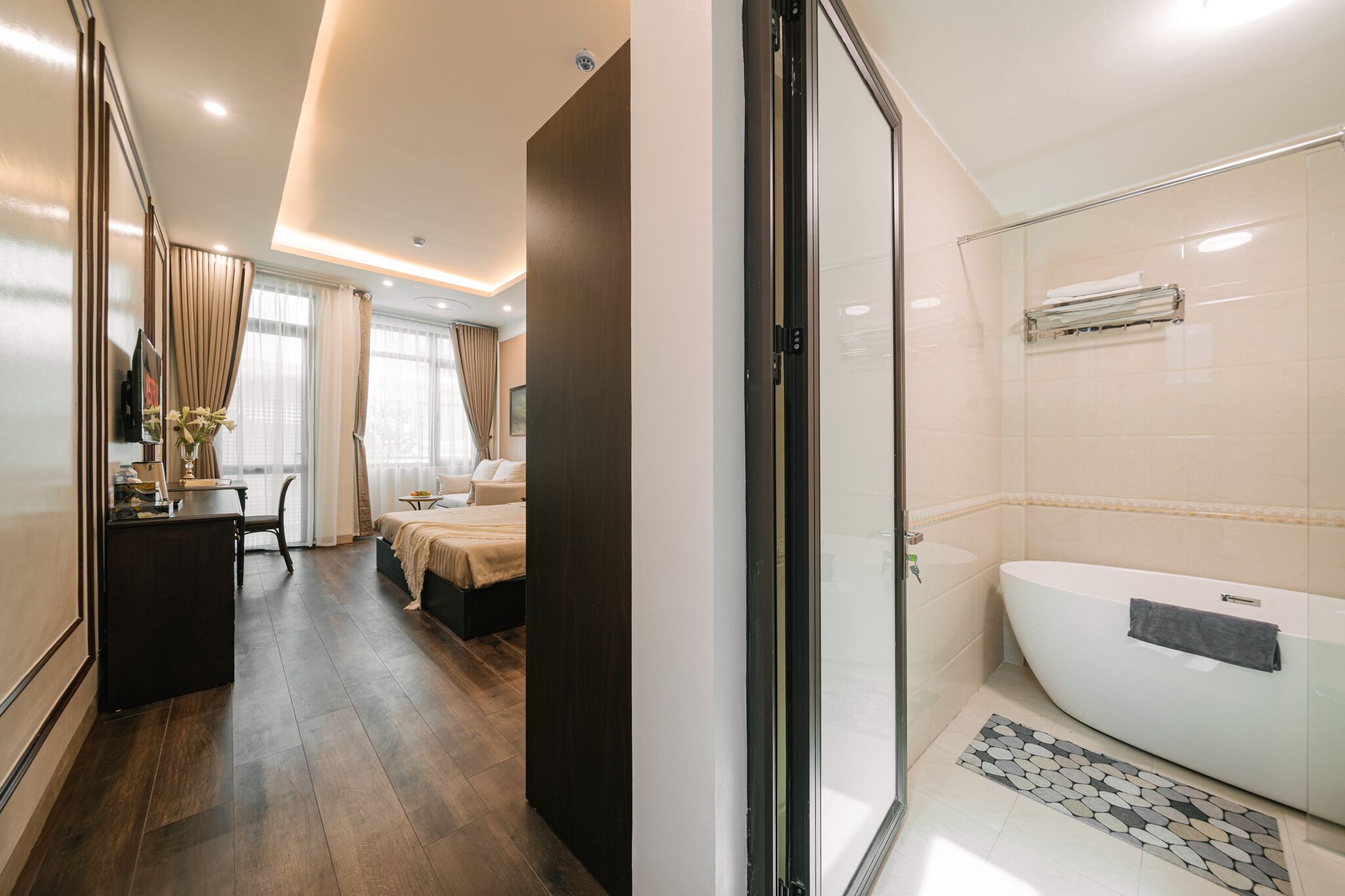 Une chambre d’hôtel avec un lit, un bureau et une salle de bain équipée d’une baignoire.