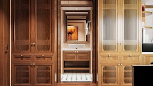 Une salle de bain avec des meubles en bois, un lavabo et un sol carrelé.