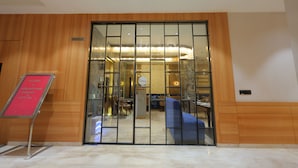 A hotel lobby with a wooden wall, a reception desk, and a seating area. - Hotel Guru Kripa Grand (3-Star Category)  (Mathura)