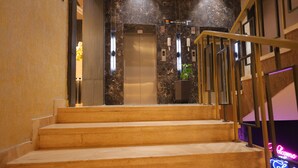 A staircase leading to an elevator with a sign indicating a way to a bar and club. - Hotel Guru Kripa Grand (3-Star Category)  (Mathura)