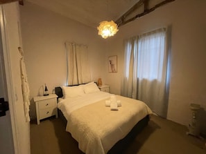 A bedroom with a bed, bedside tables, a lamp, curtains, and a ceiling light fixture. - Central, Fun & Cozy! (Jindabyne)