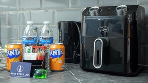 A kitchen counter with a coffee maker, two water bottles, and two cans of Fanta. - City Centre Studio | Fast Wi-Fi | Workspace | Washer/Dryer | Netflix | Air Fryer (Bradford)