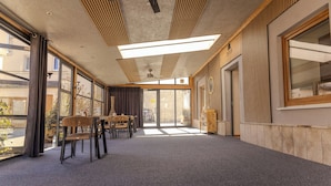 Ein großzügiger Innenraum mit hoher Decke, großen Fenstern und modernem Design.