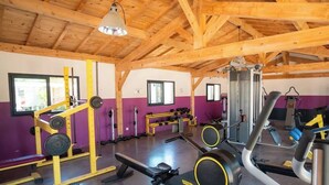 Une salle de sport équipée de matériel de musculation, de bancs et de tapis de course.