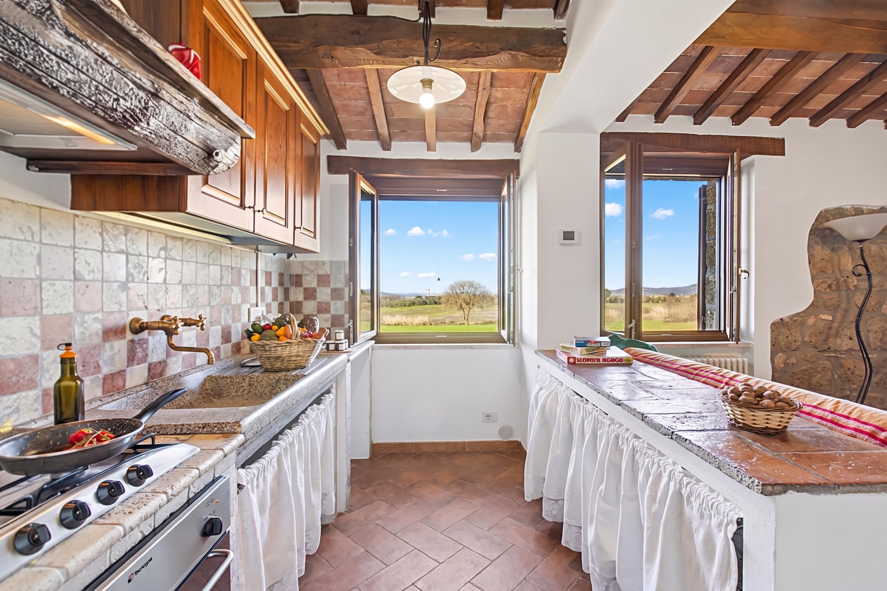 Una cocina con estufa, lavabo y ventana con vistas al paisaje.