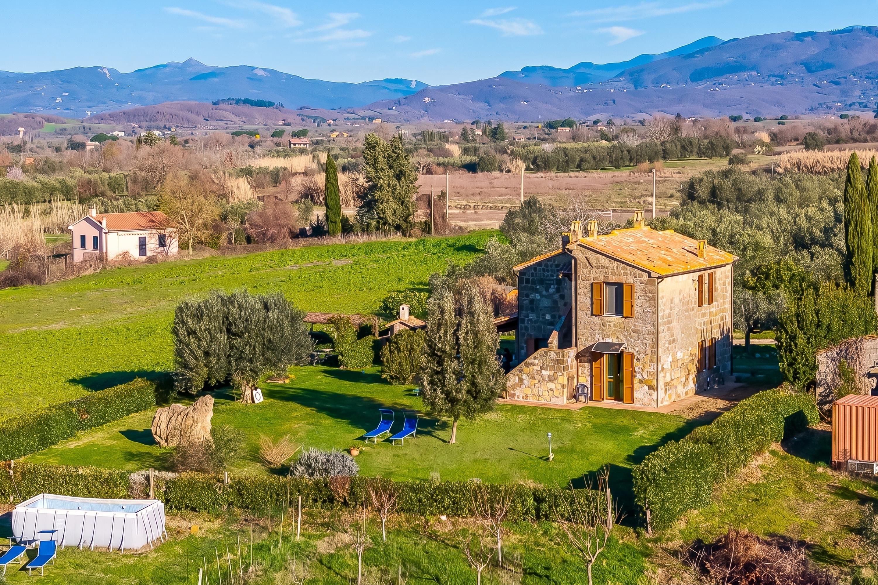 Una casa de piedra con un pequeño jardín y una piscina.