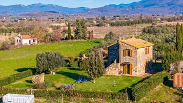 Una casa de piedra con un pequeño jardín y una piscina.