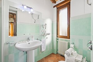 A bathroom with a sink, mirror, towel rack, and toilet. - Le Sorgenti House (Pitigliano)