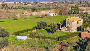 A rural landscape with a stone house, a swimming pool, and a clear view of distant mountains. - Le Sorgenti House (Pitigliano)
