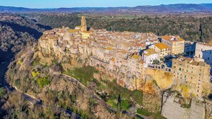 A town with a prominent tower, narrow streets, and buildings with uniform architecture. - Le Sorgenti House (Pitigliano)