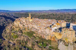 A town with a prominent tower, narrow streets, and buildings with uniform architecture. - Le Sorgenti House (Pitigliano)