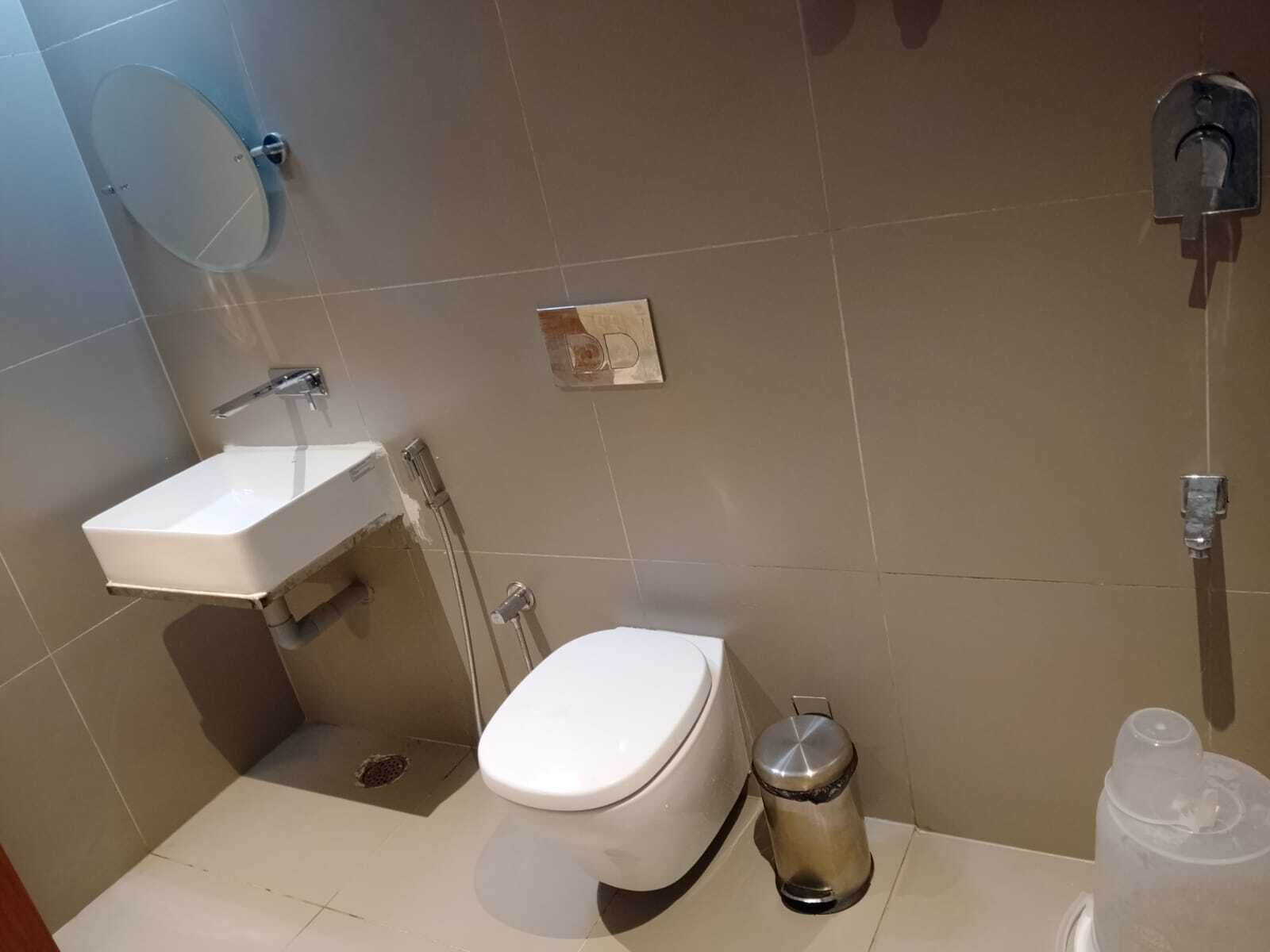 A bathroom with a toilet, sink, and shower.